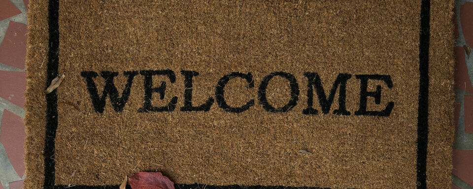 A brown outdoor floor mat with black text that reads "Welcome"